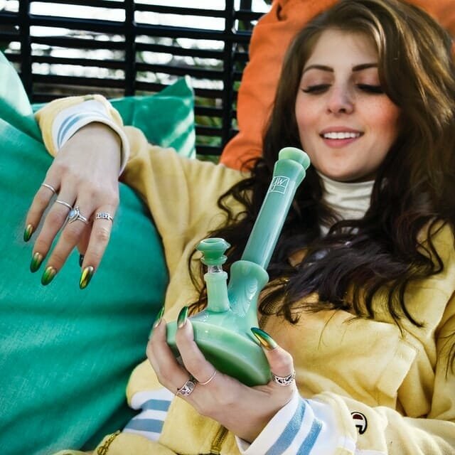 young woman smoking a bong on a lounger