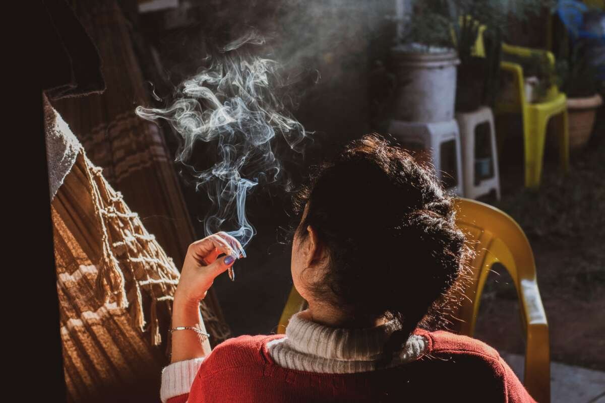 woman smoking a joint sitting in in a hammock