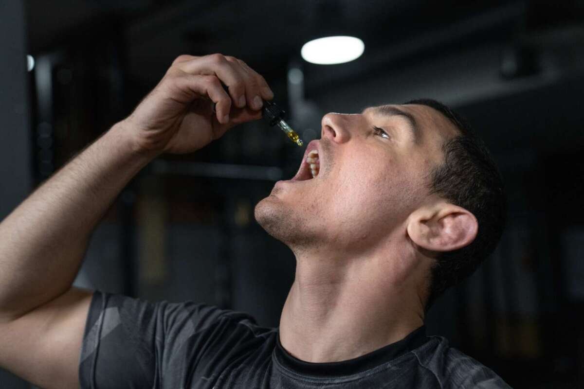 Man taking CBD oil under his toungr