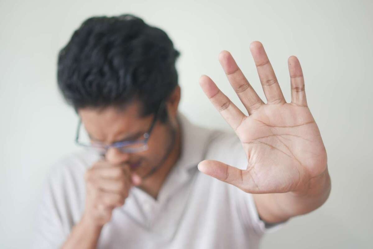 man feeling sick holding hand up cbd and motion sickness