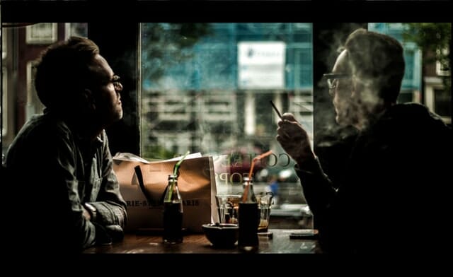 two men smoking cannabis in Amsterdam cafe.