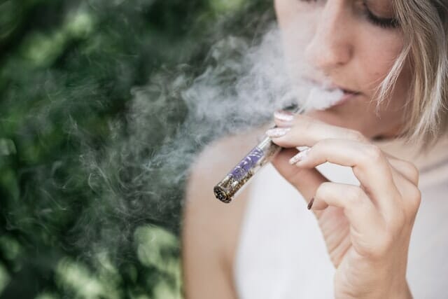 woman smoking cannabis through a one hitter