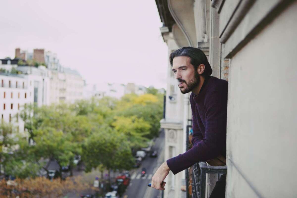 man vaping on balcony 