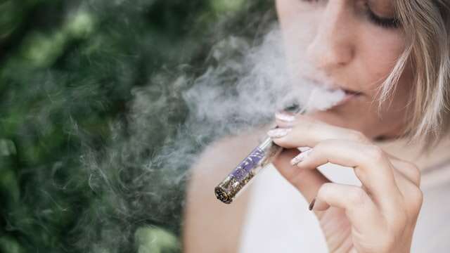 woman smoking cannabis in a chillum