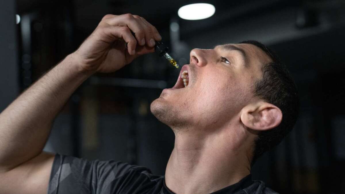 man dropping cbd oil in mouth